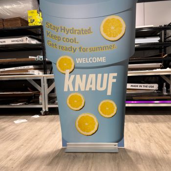Freestanding tradeshow display shaped like a beverage cup with lemon graphics in Chicago Downtown.