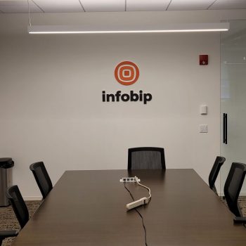 Acrylic wall sign with logo and text mounted above a conference table in Chicago Downtown.