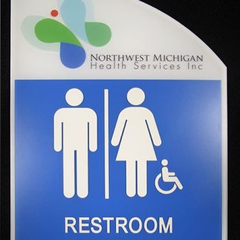Curved blue and white ADA restroom sign with braille and symbols in Chicago Downtown.