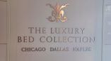 Brushed metal wall sign with decorative emblem and text mounted on white wall in Chicago Downtown.