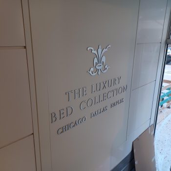 Metal wall sign with raised letters and decorative emblem inside a building in Chicago Downtown.