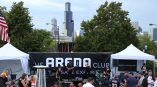 Large vinyl event banner with stage setup and tents in Chicago Downtown park.
