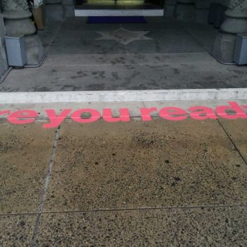 Pink vinyl floor graphic applied on concrete step at building entrance in Chicago Downtown.