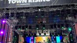 Large fabric event banner mounted on metal truss stage structure in Chicago Downtown.