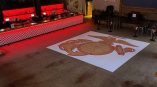 Large floor graphic of an emblem on a white background inside a bar in Chicago Downtown.