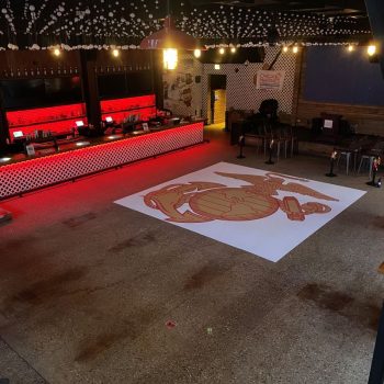 Large floor graphic of an emblem on a white background inside a bar in Chicago Downtown.