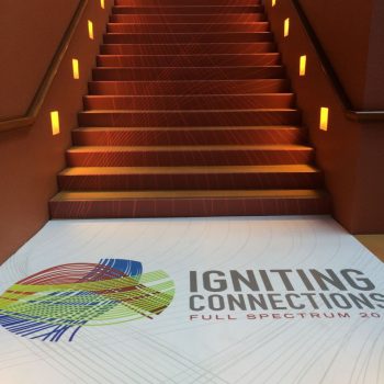 Floor graphic with colorful abstract design and text on landing of indoor stairs in Chicago