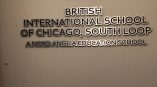 Metal wall sign with layered cutout letters and logo mounted on gray wall in Chicago Downtown.