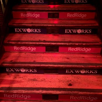 Floor stair graphics with red and blue branded vinyl decals on wooden steps in Chicago Downtown.