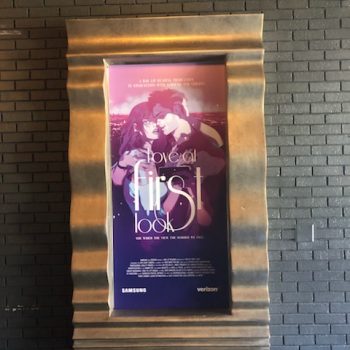 Framed vertical poster mounted on a textured brick wall in Chicago Downtown.