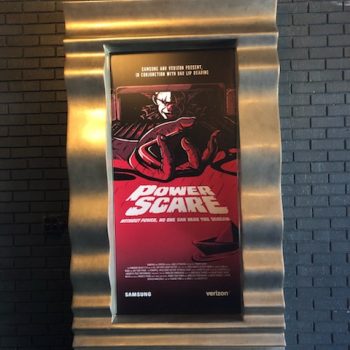 Metal framed poster display with corrugated border mounted on brick wall in Chicago Downtown.