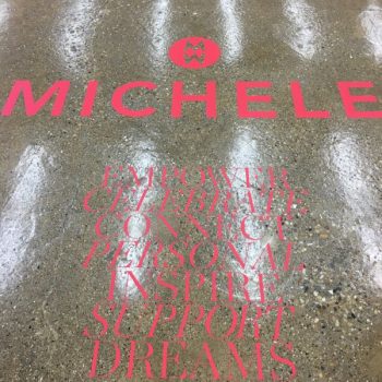 Red vinyl floor graphics with text applied on polished concrete in Chicago Downtown.