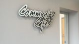 Custom cut metal wall sign with black and white lettering mounted indoors in Chicago Downtown.