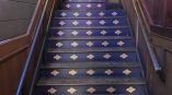 Indoor stair riser graphics with repeated logos on wooden steps in Chicago Downtown.