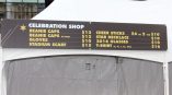 Large vinyl banner with event merchandise pricing mounted on a white tent in Chicago Downtown.