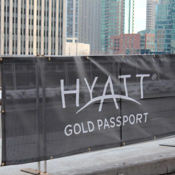 Black mesh banner with grommets mounted on metal barricade in Chicago Downtown.