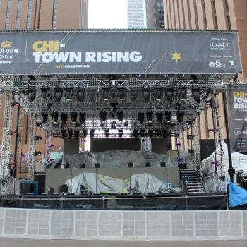 Large vinyl event banners and stage truss setup with lighting in Chicago Downtown.