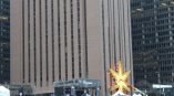 Large yellow star-shaped event sign mounted on a metal frame with tents in Chicago Downtown.