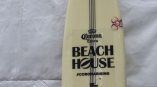 White surfboard with black vinyl decals and stickers displayed against a fabric backdrop in Chicago