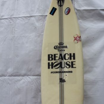 White surfboard with black vinyl decals and stickers displayed against a fabric backdrop in Chicago