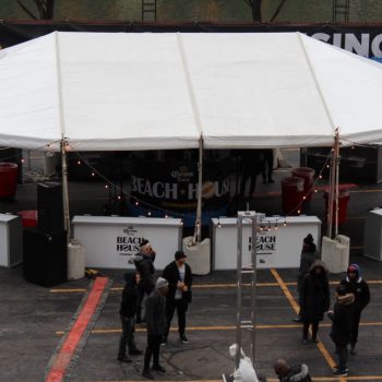 Outdoor event tent with branded vinyl banners and barricade signs in Chicago Downtown.