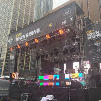 Outdoor event stage with large vinyl banners and LED screens in Chicago Downtown.