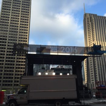 Large vinyl event banner mounted on scaffolding above a stage in Chicago Downtown.