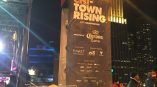 Large vertical event banner on metal frame with logos at night in Chicago Downtown.