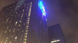 Illuminated building-mounted LED sign with blue lights on a skyscraper in Chicago Downtown.