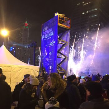 Large vertical event banner on scissor lift with fireworks and crowd in Chicago Downtown.