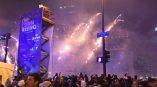 Large vertical event banner on a metal frame at a crowded outdoor celebration in Chicago Downtown.