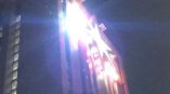 Illuminated rooftop lightbox sign on a tall building at night in Chicago Downtown.