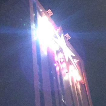 Illuminated rooftop lightbox sign on a tall building at night in Chicago Downtown.