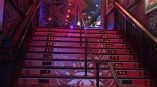 Red and white floor stair graphics with a spider design on wooden steps in Chicago Downtown.