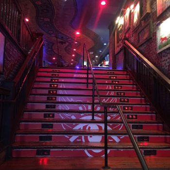 Red and white floor stair graphics with a spider design on wooden steps in Chicago Downtown.