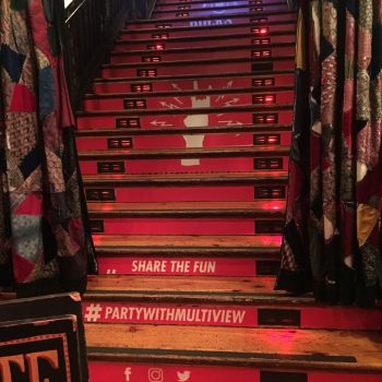 Red vinyl stair graphics with social media icons and symbols on wooden stairs in Chicago Downtown.