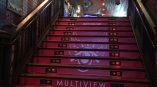 Red vinyl stair graphics with white design and text on wooden stairs in Chicago Downtown.