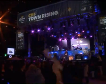 Large outdoor event stage banner and vertical hanging signs with lighting in Chicago Downtown.