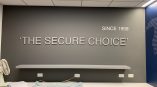 Metal wall sign with raised letters mounted on gray wall above countertop in Chicago Downtown.