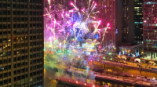 Large event banner signage displayed on a river barge with fireworks in Chicago Downtown.