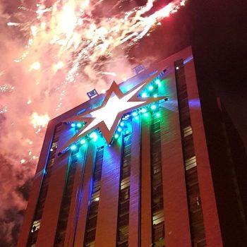 Large building banner with star graphic and fireworks in Chicago Downtown skyline.