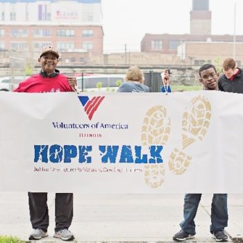 Two men holding banner to promote Volunteers of America's Hope Walk