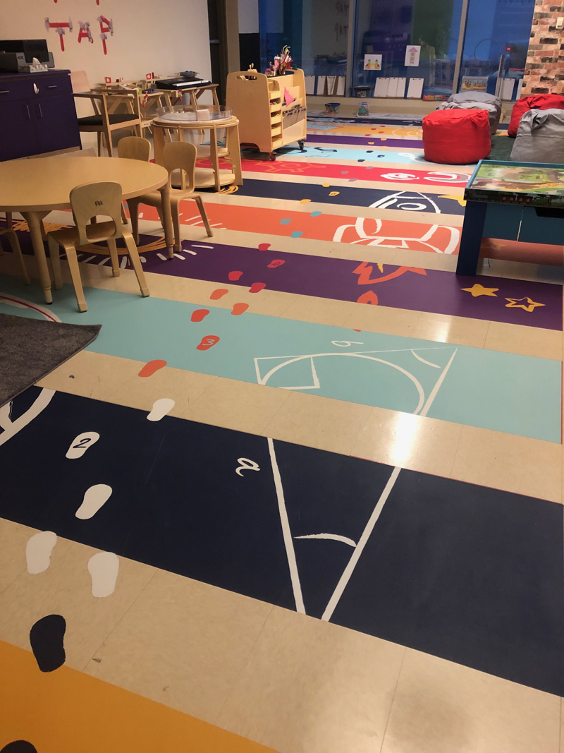 Floor graphic in school with educational images and footsteps