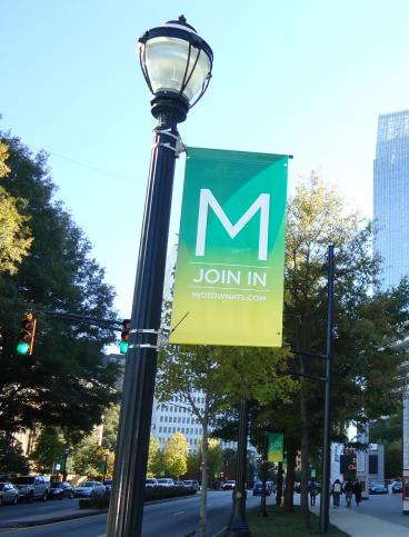 Banner hanging from a lamp post that is advertising Midtown events. 