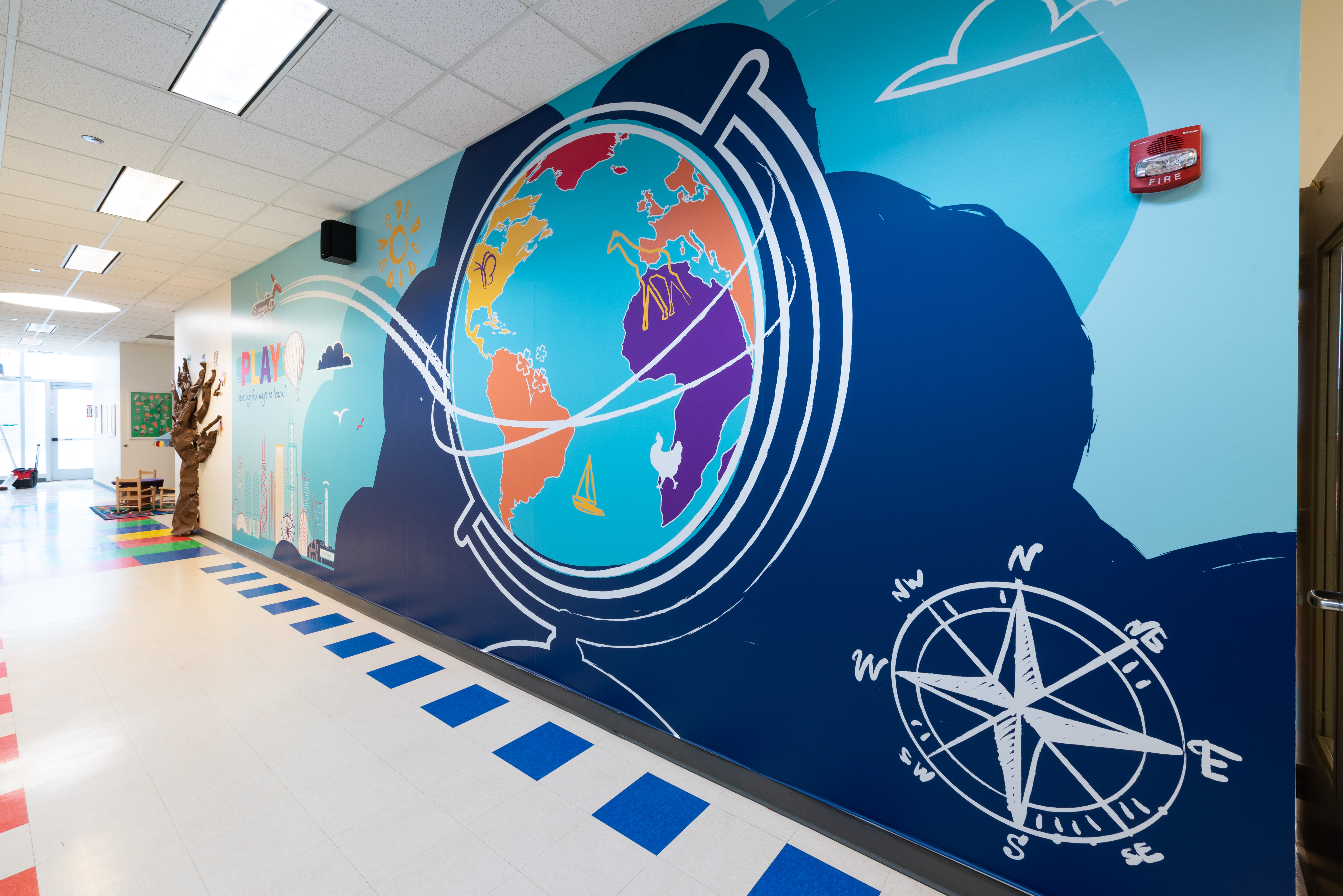 A large environmental graphic of globe and compass 