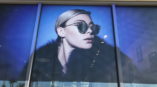 large window covering of woman wearing sunglasses
