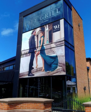 Advertising sign on side of building with cityscape view