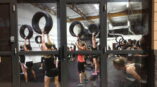 Window graphics of an exercise class where woman are lifting tires