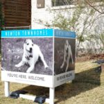 Newton Homes outdoor welcome signs with image of dog