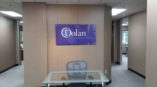 Dolan Consulting Group sign behind a desk